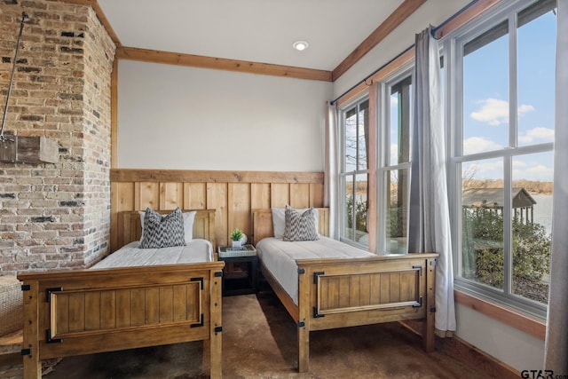 bedroom featuring multiple windows and a wainscoted wall