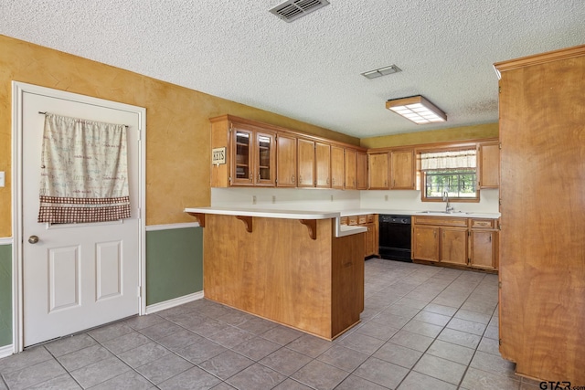 16780 Wilson Rd, Tyler, TX 75707 - kitchen featuring visible vents, a peninsula, light tile patterned flooring, a breakfast bar, and dishwasher