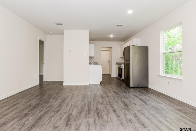 613 S Baxter, Tyler, TX 75701 - unfurnished living room featuring wood finished floors and baseboards
