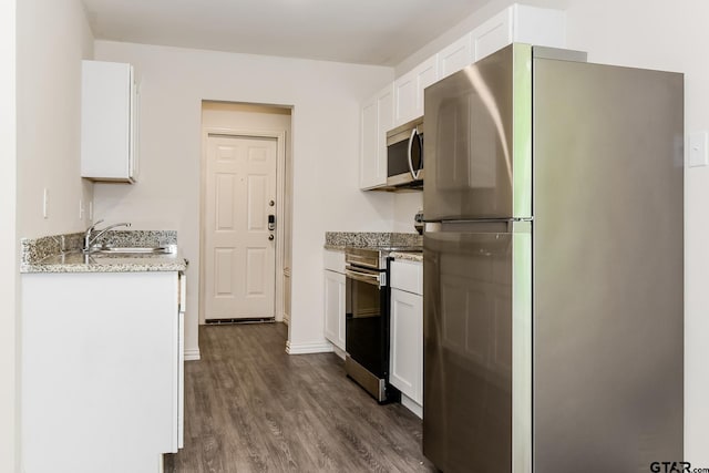 613 S Baxter, Tyler, TX 75701 - kitchen featuring appliances with stainless steel finishes, white cabinets, dark wood finished floors, and light stone counters