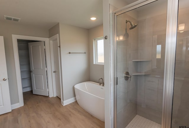 414 Bluebonnet Cir, Chandler, TX 75758 - full bath featuring a stall shower, a freestanding tub, baseboards, wood finished floors, and recessed lighting