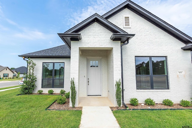 414 Bluebonnet Cir, Chandler, TX 75758 - view of front of home featuring a front yard, brick siding, and roof with shingles