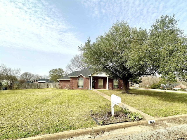 single story home featuring fence, a front lawn, and brick siding