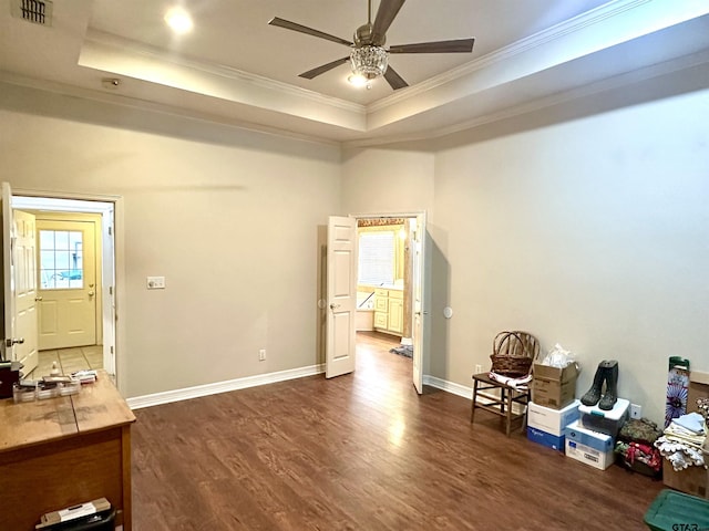 interior space with visible vents, crown molding, a tray ceiling, and wood finished floors