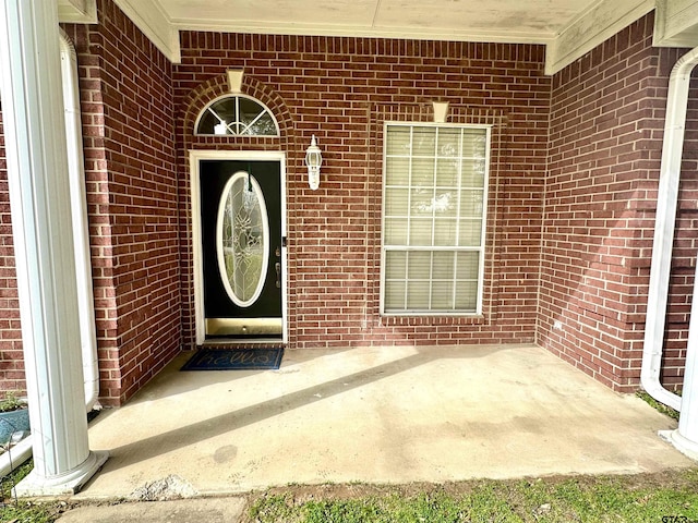 view of exterior entry with brick siding