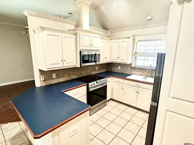 kitchen with stainless steel appliances, dark countertops, light tile patterned flooring, and a sink