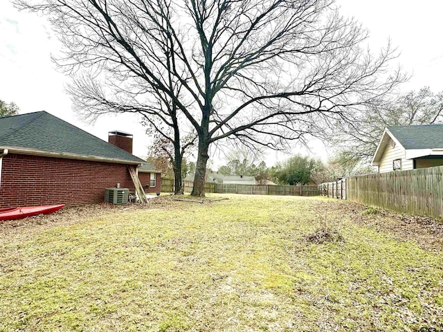 view of yard with fence and central AC unit