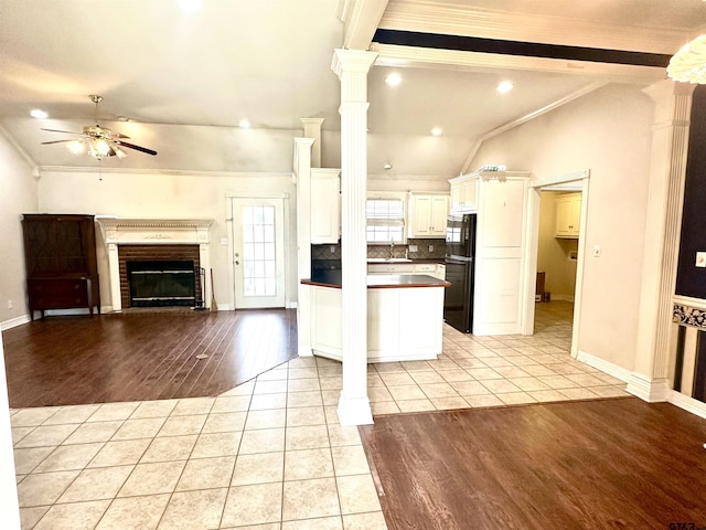 kitchen featuring open floor plan, light tile patterned floors, freestanding refrigerator, and crown molding