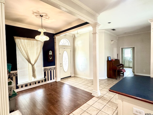 entrance foyer with light tile patterned floors, visible vents, baseboards, ornate columns, and crown molding