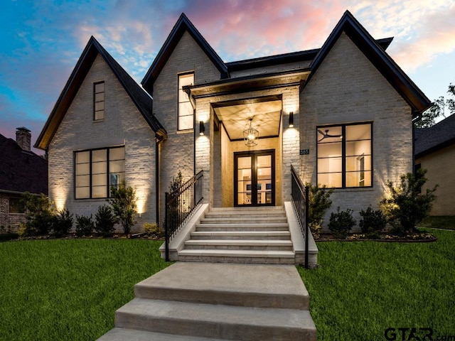 view of front of home featuring a lawn and french doors