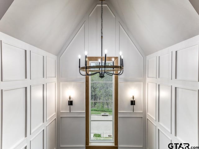 doorway featuring vaulted ceiling and a notable chandelier