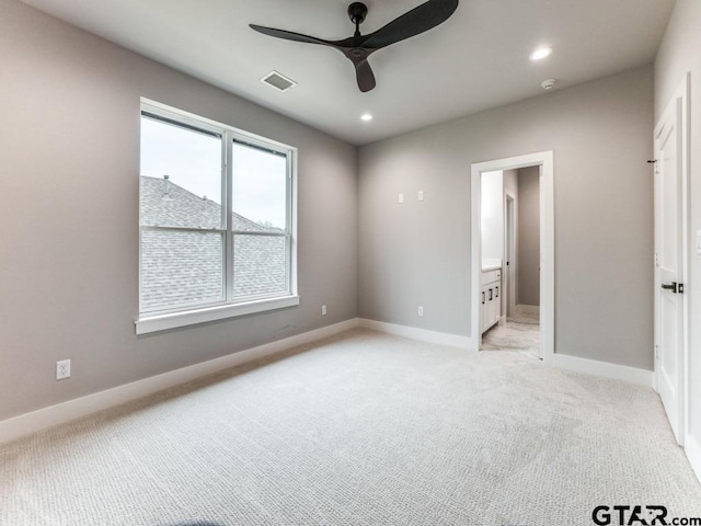 unfurnished bedroom featuring connected bathroom, light colored carpet, and ceiling fan