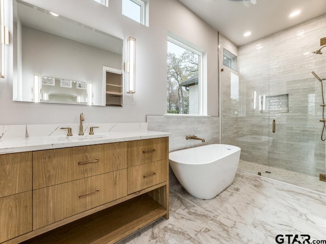 bathroom with vanity and shower with separate bathtub