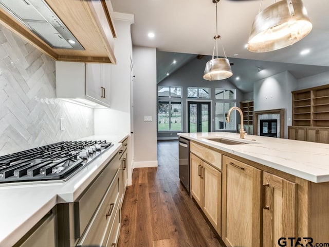 kitchen featuring stainless steel appliances, sink, backsplash, hanging light fixtures, and lofted ceiling