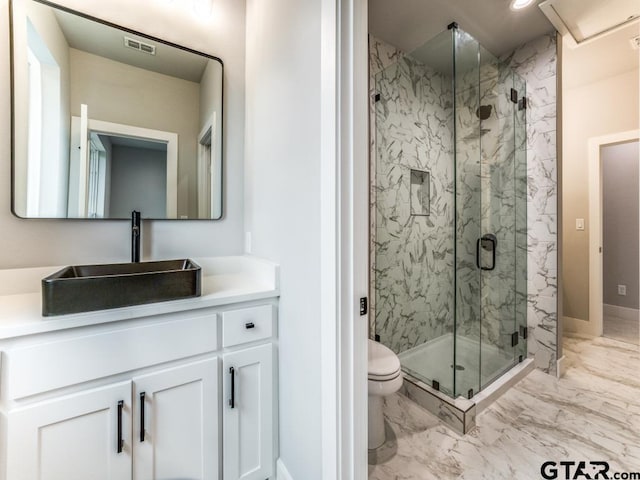 bathroom with toilet, vanity, and a shower with door