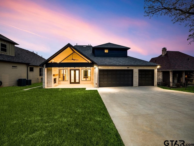 view of front of property with a garage and a yard