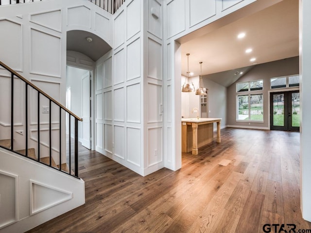 interior space featuring french doors, hardwood / wood-style floors, vaulted ceiling, and an inviting chandelier