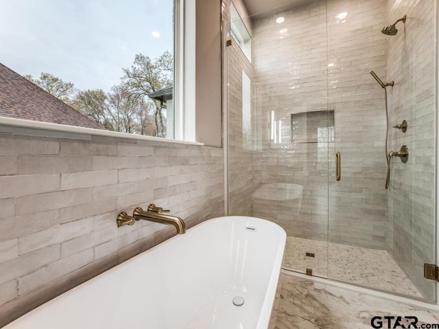 bathroom featuring separate shower and tub