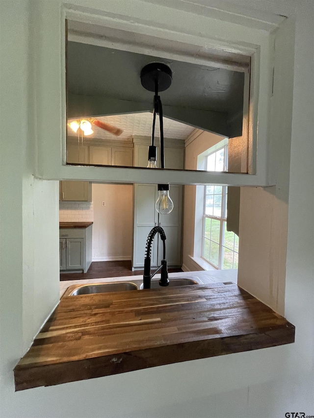 kitchen featuring decorative backsplash, sink, and wooden counters