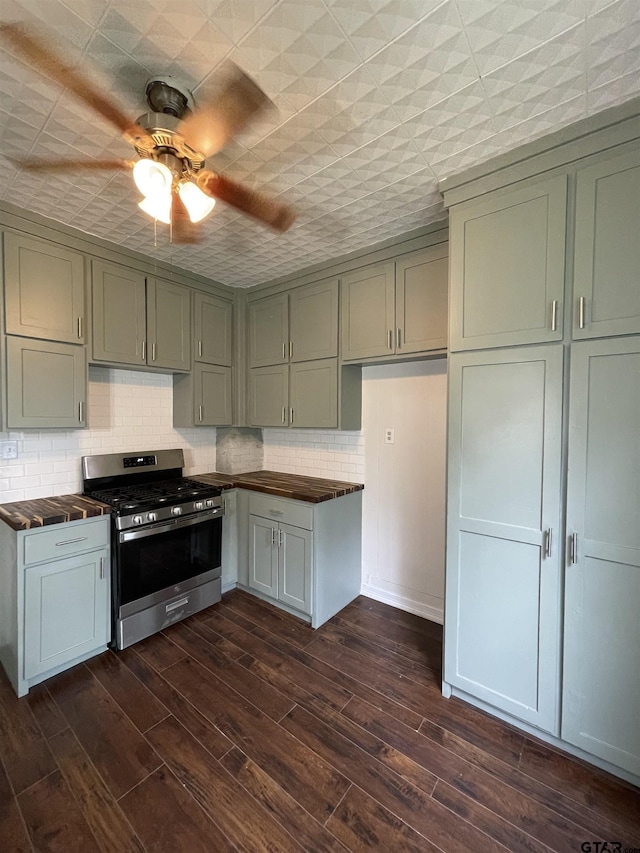 kitchen with decorative backsplash, dark hardwood / wood-style flooring, stainless steel range with gas cooktop, and ceiling fan