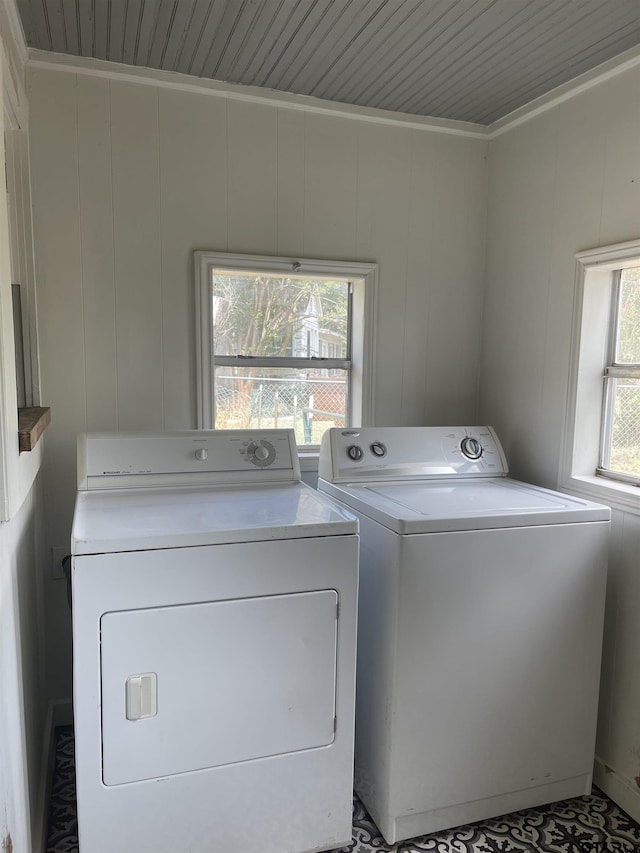 laundry area featuring wooden walls and washer and dryer