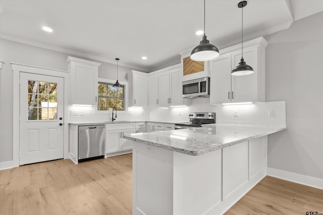 kitchen featuring white cabinets, decorative light fixtures, and stainless steel appliances