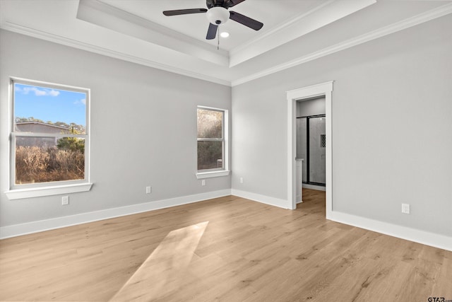 unfurnished room featuring a tray ceiling, light hardwood / wood-style flooring, ceiling fan, and ornamental molding