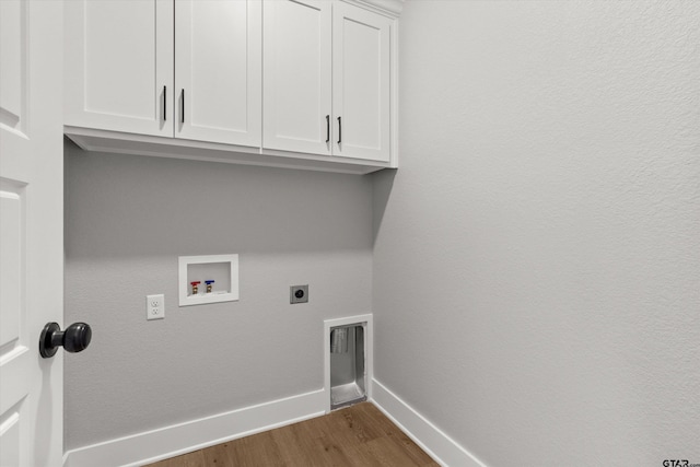 laundry area featuring electric dryer hookup, cabinets, dark wood-type flooring, and hookup for a washing machine