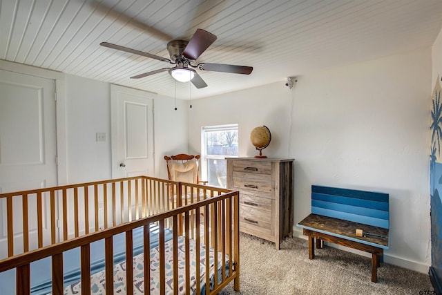 bedroom with ceiling fan, light colored carpet, wooden ceiling, and a nursery area