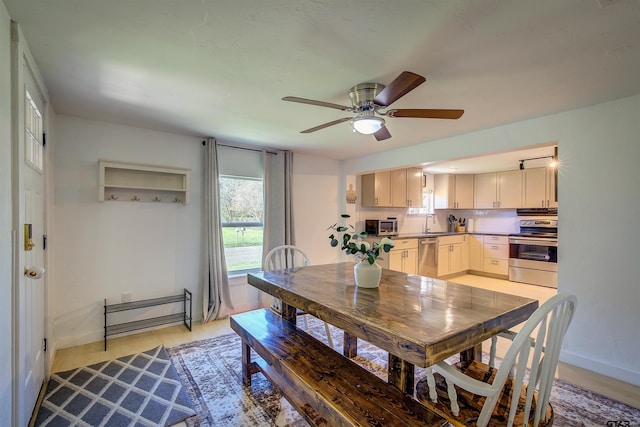 dining space featuring ceiling fan, sink, and light hardwood / wood-style flooring