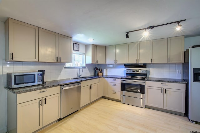 kitchen featuring sink, gray cabinets, light wood-type flooring, appliances with stainless steel finishes, and extractor fan