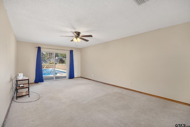 carpeted spare room featuring a textured ceiling and ceiling fan