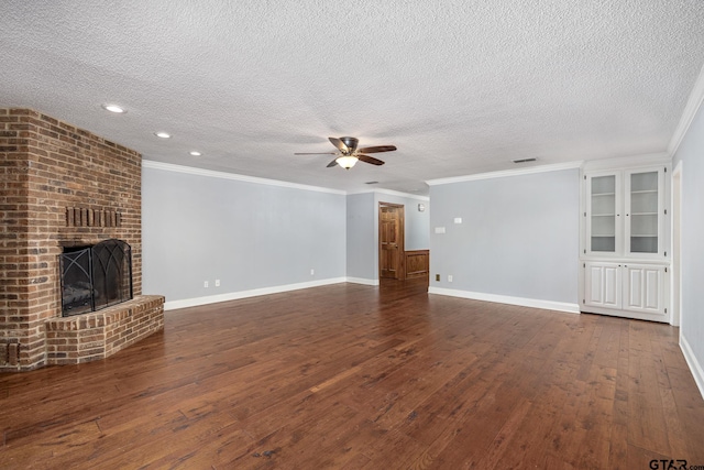 unfurnished living room featuring a textured ceiling, dark hardwood / wood-style flooring, a brick fireplace, and ornamental molding