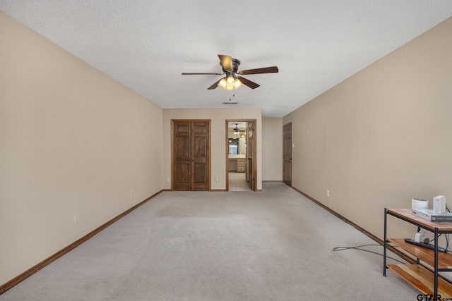 carpeted spare room with ceiling fan and a textured ceiling