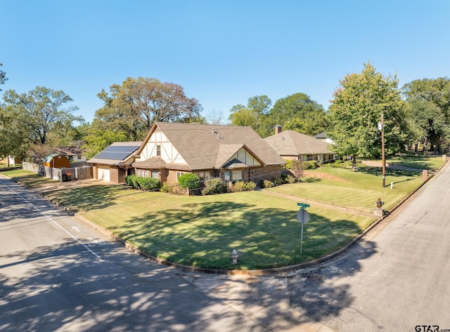 tudor-style house with solar panels and a front lawn