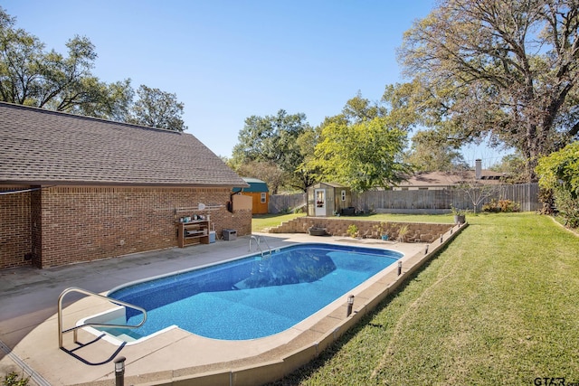 view of swimming pool with a yard, a patio area, and a storage shed