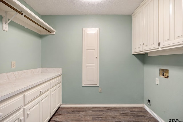 laundry room featuring cabinets, washer hookup, a textured ceiling, and dark wood-type flooring