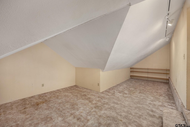 bonus room featuring carpet flooring, a textured ceiling, and vaulted ceiling