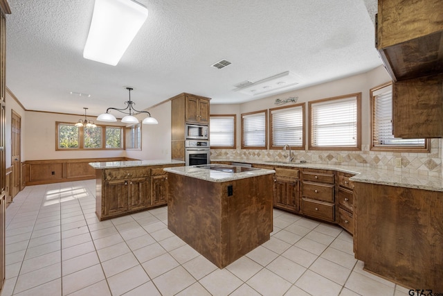 kitchen with sink, hanging light fixtures, tasteful backsplash, a kitchen island, and stainless steel appliances