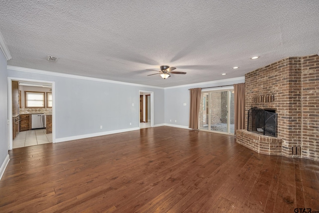 unfurnished living room with a fireplace, a textured ceiling, light hardwood / wood-style flooring, and crown molding