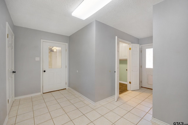 entryway featuring light tile patterned flooring and a textured ceiling