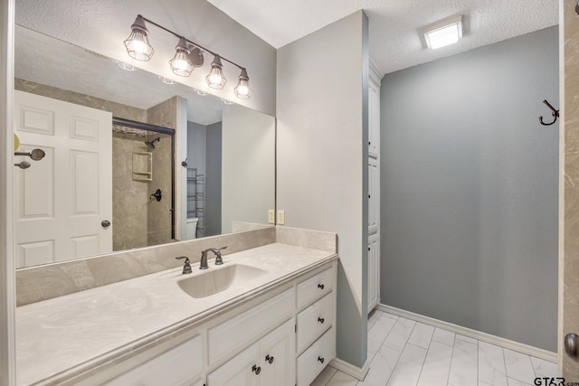 bathroom featuring tile patterned flooring, vanity, a shower with shower door, and a textured ceiling