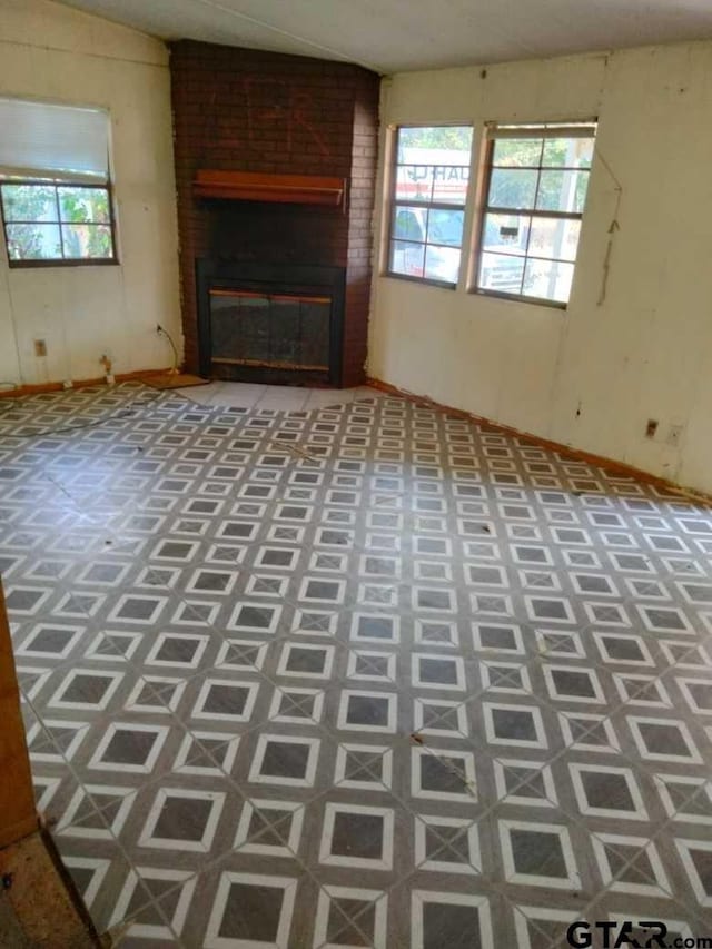 unfurnished living room with a fireplace and a healthy amount of sunlight