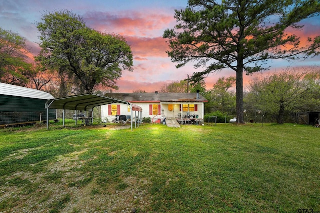 yard at dusk featuring a carport