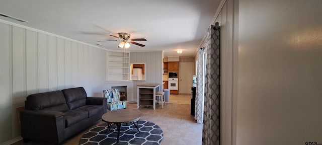 living room with a ceiling fan and crown molding