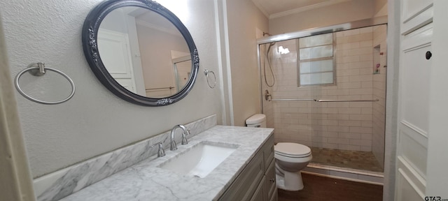 bathroom with toilet, ornamental molding, a shower stall, vanity, and a textured wall