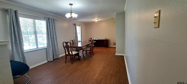 dining space with wood finished floors, crown molding, and baseboards
