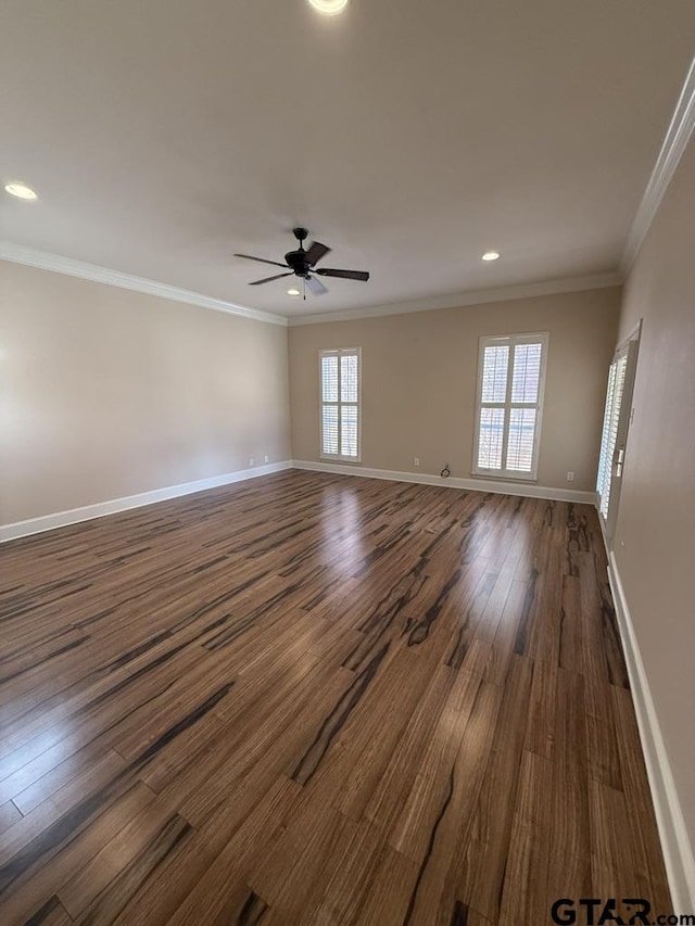 spare room featuring dark wood-type flooring, ornamental molding, and ceiling fan