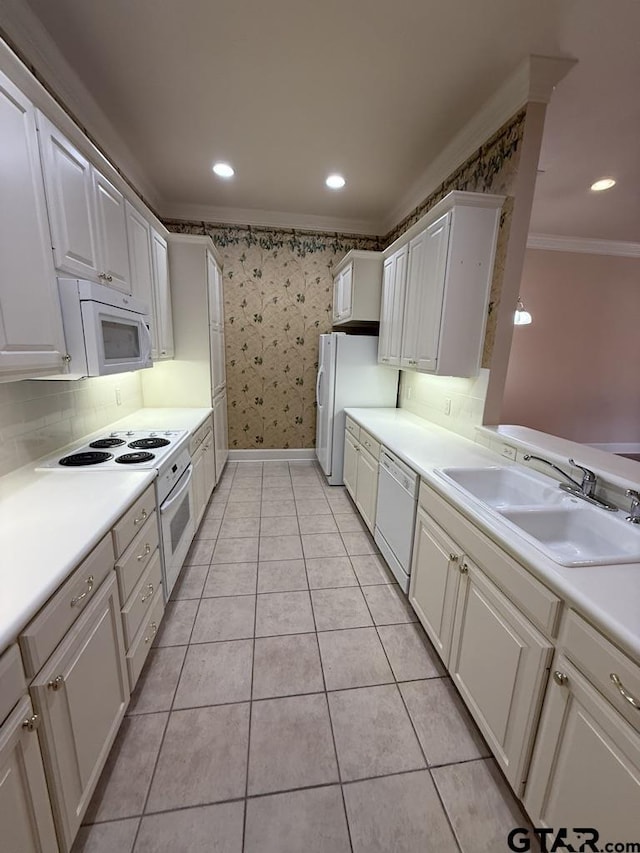 kitchen featuring light tile patterned flooring, white cabinetry, sink, ornamental molding, and white appliances