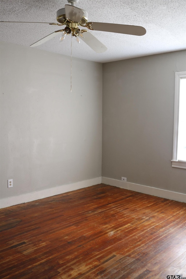 spare room with a textured ceiling, dark hardwood / wood-style floors, and ceiling fan